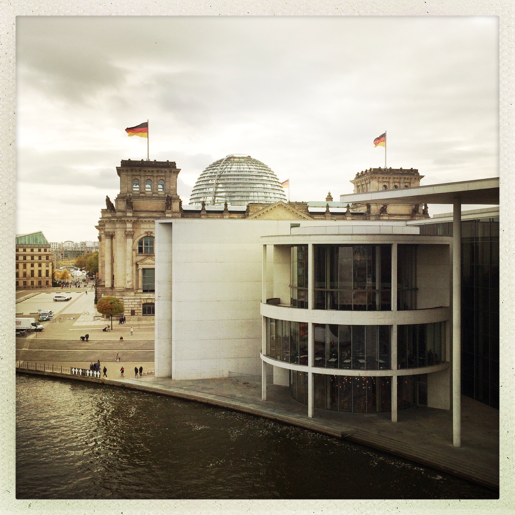 Im Vordergrund ein Teil des Paul-Löbe-Hauses für die Bundestagsabgeordneten, im Hintergrund das Reichstagsgebäude mit der Kuppel (fotografiert von der Abgeordnetenbrücke über der Spree, genau an der Stelle, an der früher die Mauer stand)